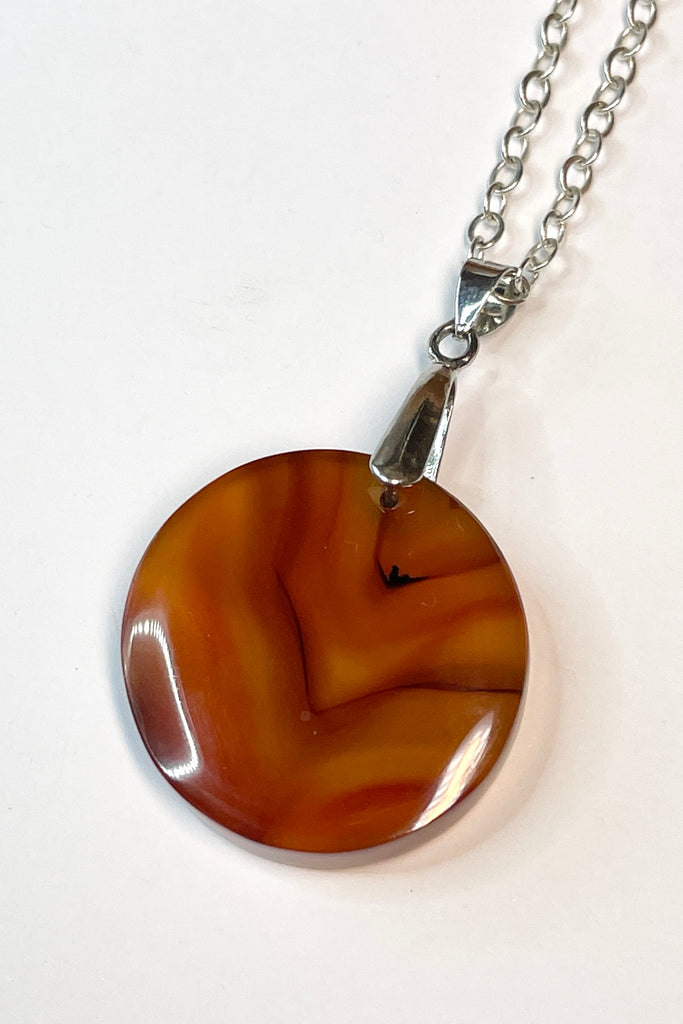 This pendant is a lovely piece of clear and rusty orange Agate stone that has been skillfully cut into a perfect circle then polished, by ROAM Ladies Lapidary Collective in Sakaraha, Madagascar. 