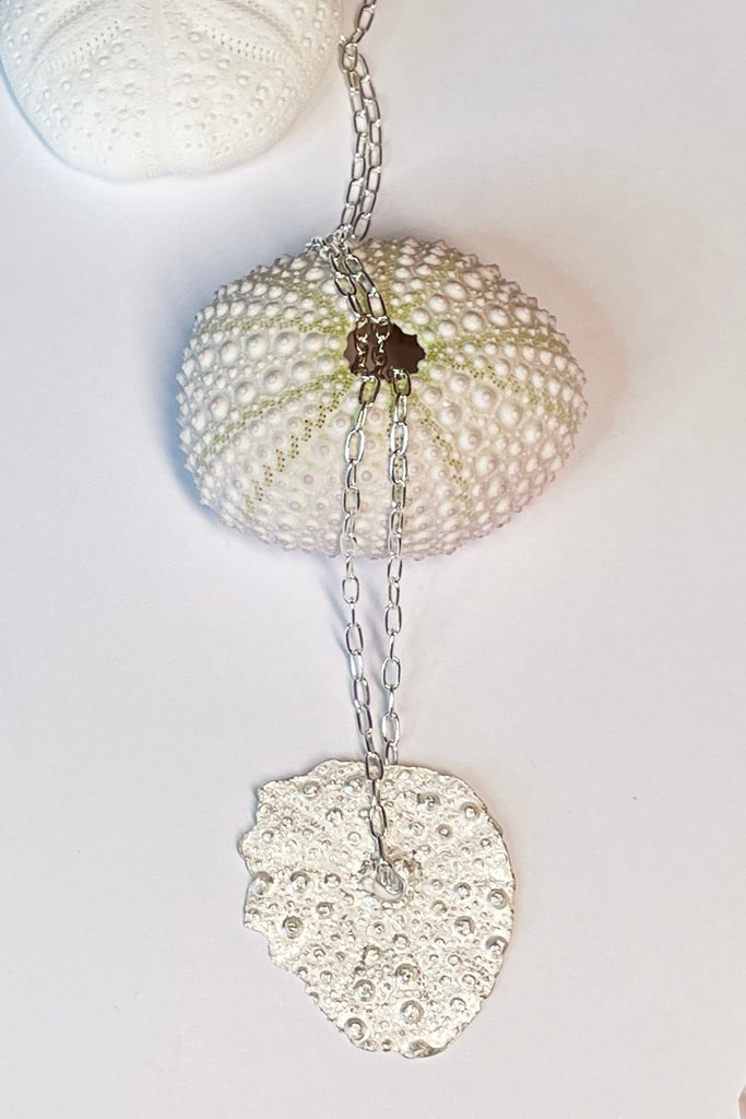 . The centre piece is silver, it is cast from a sea urchin shell. This pendant  is so delicate and has the feeling of a tiny sparkly shard floating in the ocean. 