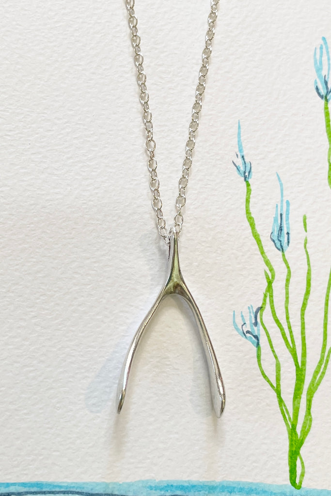 A small silver wishbone pendant, this is a vintage piece 