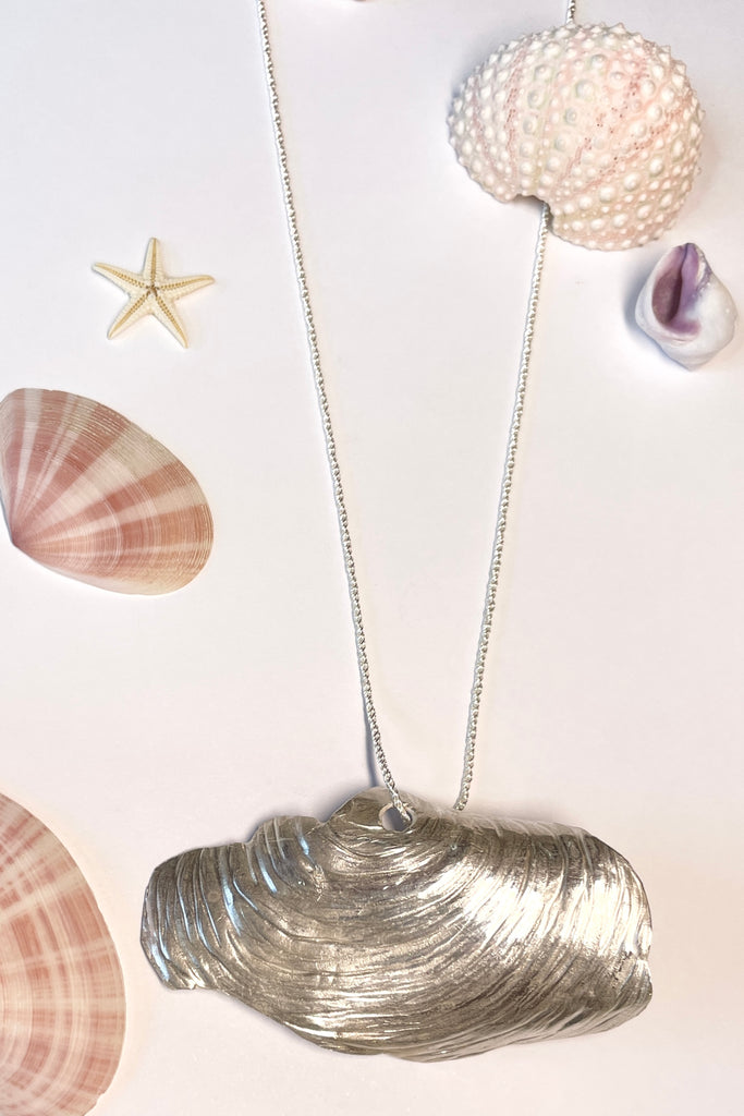 The centre piece is solid silver, it is a cast from a shell found on the Noosa North Shore. The necklace is just so special, the design is original as it is cast directly from the shell. The back of the piece is beautifully inscribed with a pattern of bubbles and waves.