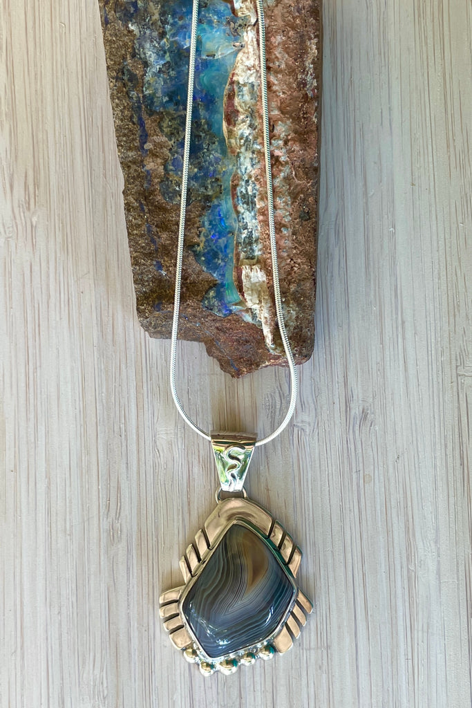 An intriguing powerful and reflecting stone pendant. A modernist pendant in a unique design, the blue Labradorite stone was cut and faceted by a local Sunshine Coast stone artist,