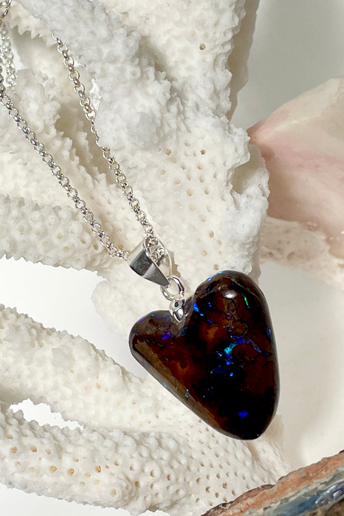 This intriguing and unique piece of opal was cut and polished into the heart shape for Mombasa Rose in Noosa, Queensland. The flashes of turquoise and teal go across and deep into the stone, giving it a flashing twinkling look. 