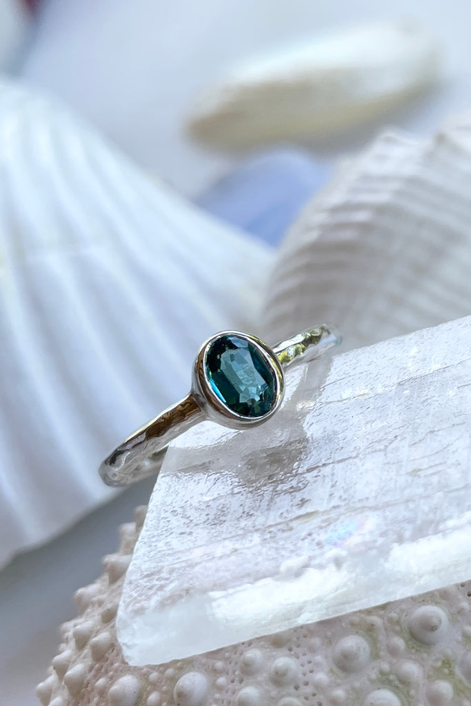 The hammered band on this ring has a slightly textured finish, giving it a hand made feel, complementing the beautiful 6x4mm natural blue tourmaline gemstone set into the ring. A very modern and striking design.