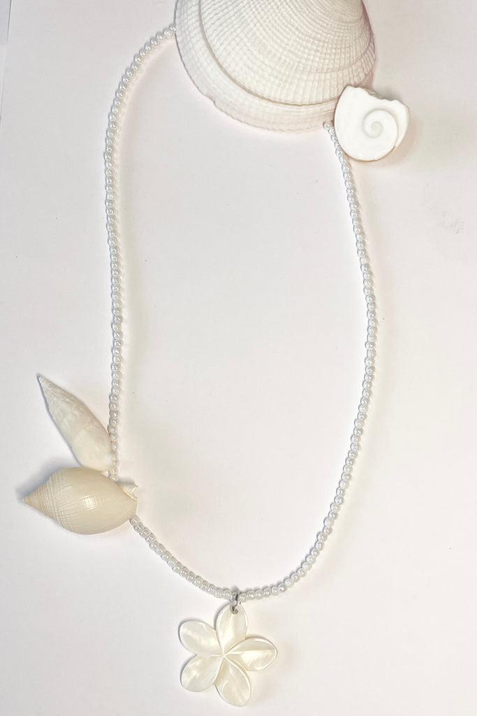 hand carved from Mother of Pearl shell all carry the distinctive marks of the artist who created them, no two flowers are ever alike,  strung on pearlescent white glass beads