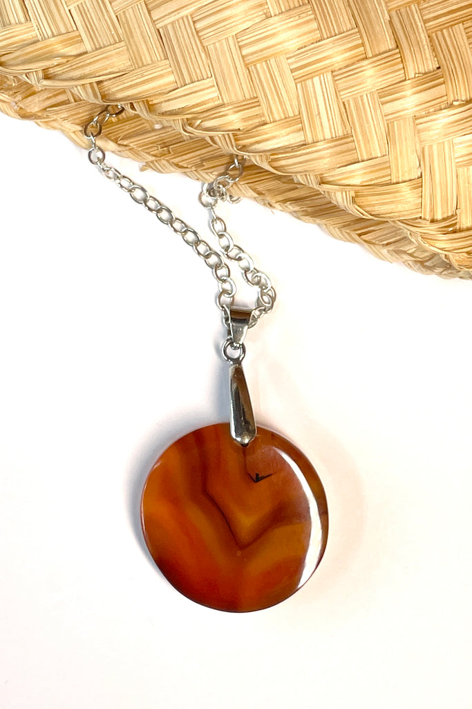 This pendant is a lovely piece of clear and rusty orange Agate stone that has been skillfully cut into a perfect circle then polished, by ROAM Ladies Lapidary Collective in Sakaraha, Madagascar. 