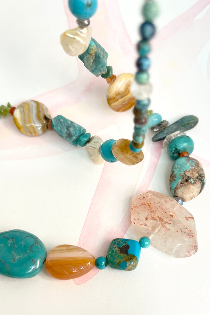 The necklace features a hand carved Zuni bears bought in Taos new Mexico. Stones are Natural Turquoise, Herkimer Diamond, Kyanite rough shards, Pearl, natural Sunstone, Strawberry Quartz, Banded Agate, Peridot and Labradorite .