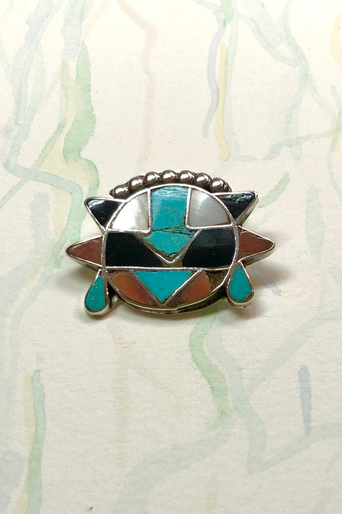 Echo Brooch Zuni Silver and Turquoise Inlay is a mysterious design brooch featuring turquoise stone, Coral and Shell.