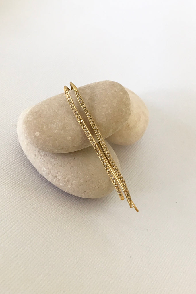 The name is Earth Moon, the style is inspired by tiny slivers of moonlight lighting the golden beach sand. Made in gold vermeil and tiny sparkling white topaz gemstones, the finish is quiet and naturalistic, the surface is matte. 