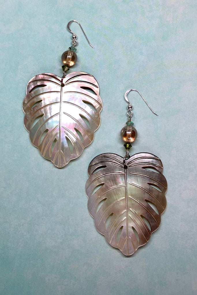 The gorgeous leaf in gold and silvery bronze Mother of Pearl has been hand cut and polished. At the top there is an iridescent crystal bead and a swarovski crystal bead. These earrings are made exclusively for Mombasa Rose
