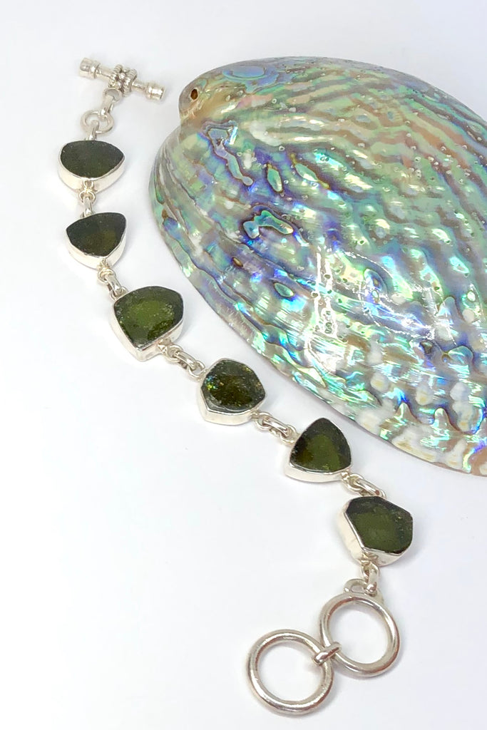 Echo Bracelet Tourmaline Green, each of the six stones  has been individually set and rim set into 925 silver.  The stones are all cut and polished into different shapes and linked in 925 silver.