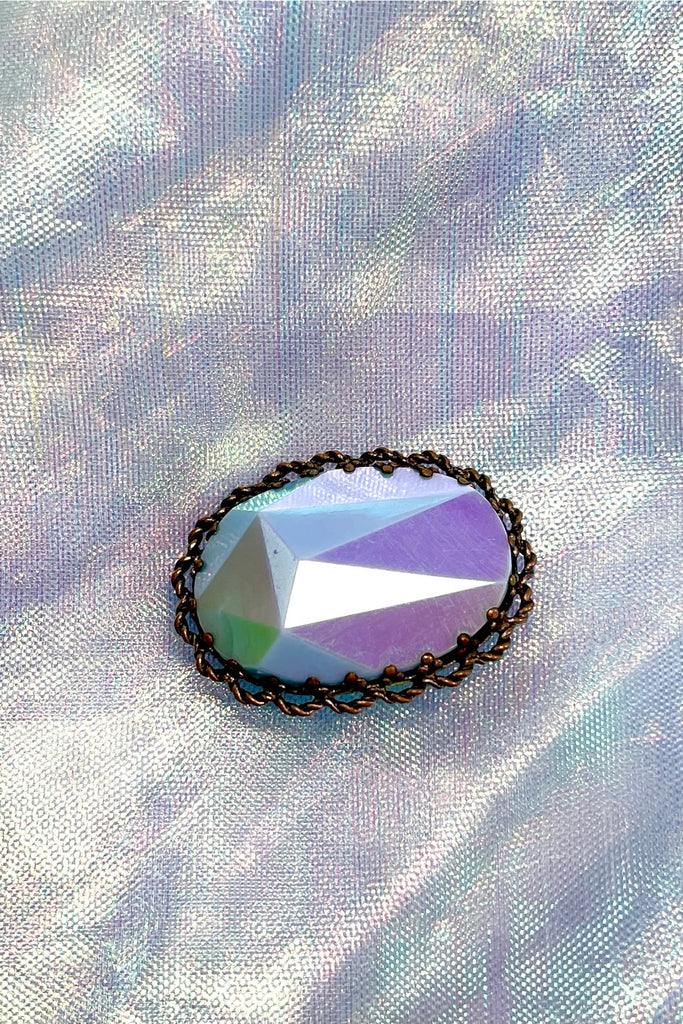 An old and unusual brooch, most likely from the 1930's. The blue is a coated glass the edge is metal