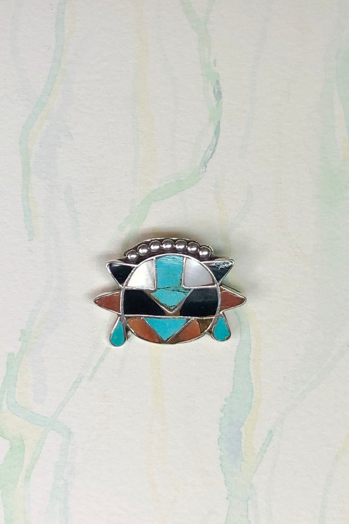 Echo Brooch Zuni Silver and Turquoise Inlay is a mysterious design brooch featuring turquoise stone, Coral and Shell.