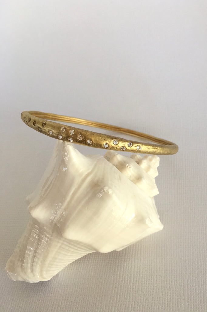 This adorable bangle has luna appeal it is handcrafted in gold plated  silver vermeil. The gems are studded randomly and will sparkle at different angles