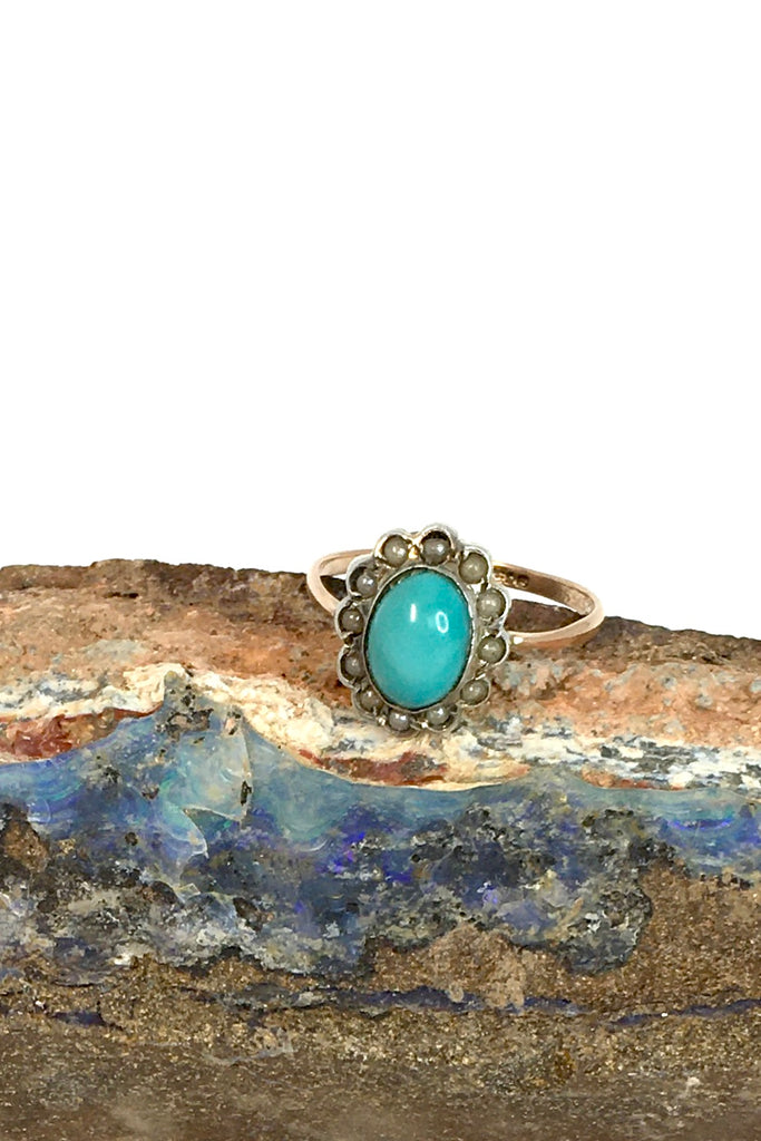 This Vintage with a solid turquoise centre stone has a surround of old 1/2 pearls, this ring has a fine band in 9ct gold. 