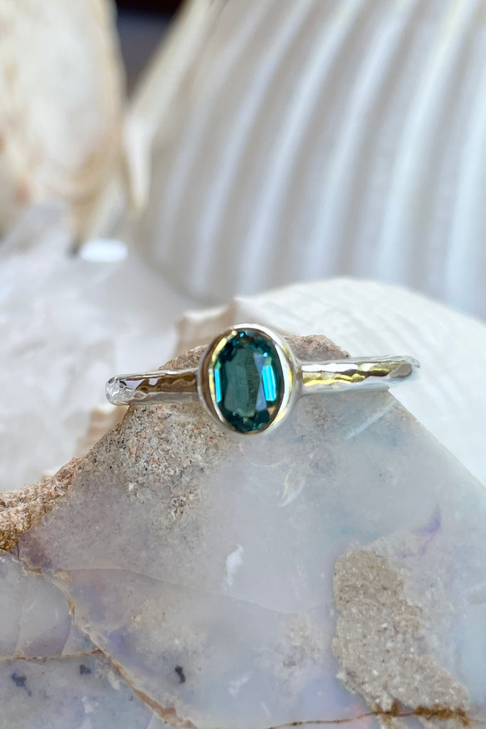 The hammered band on this ring has a slightly textured finish, giving it a hand made feel, complementing the beautiful 6x4mm natural blue tourmaline gemstone set into the ring. A very modern and striking design.