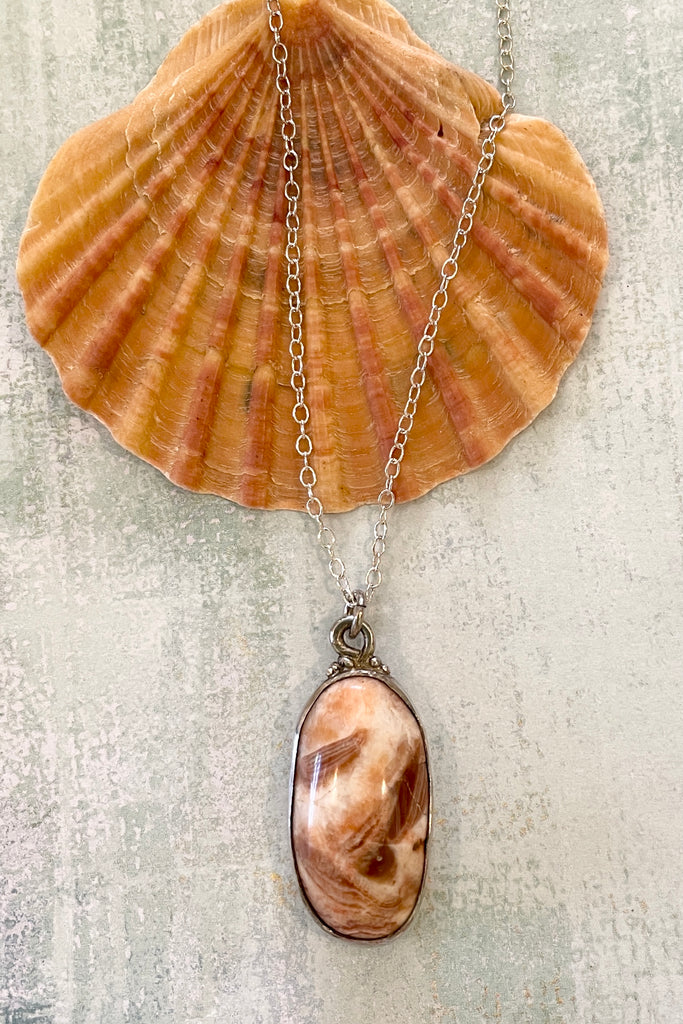 pendant features a very pretty polished stone. It comes on a silver chain.