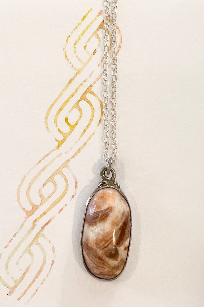 pendant features a very pretty polished stone. It comes on a silver chain.