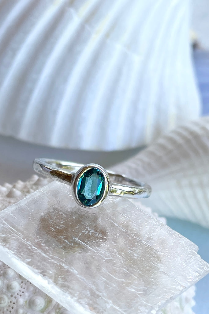 The hammered band on this ring has a slightly textured finish, giving it a hand made feel, complementing the beautiful 6x4mm natural blue tourmaline gemstone set into the ring. A very modern and striking design.