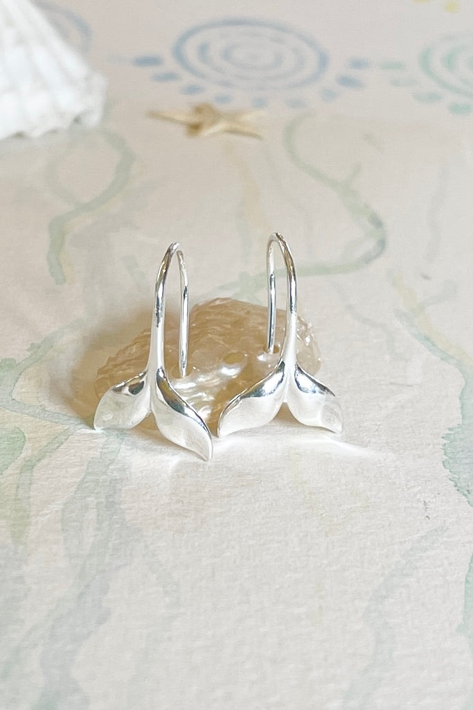 Silver earring whale tail.