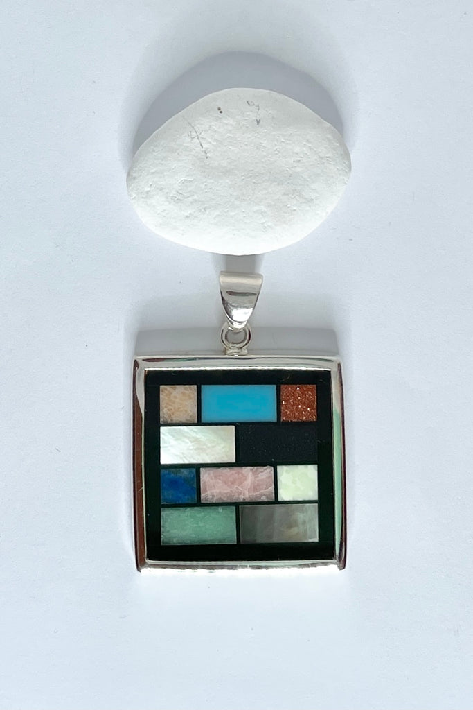 This amazing silver and shell inlay pendant is completely unique and handmade. Inspired by the colours of  on an Ndebele African house paint design, each piece is slightly different, the mosaics are in the same order but stone patterns may vary.