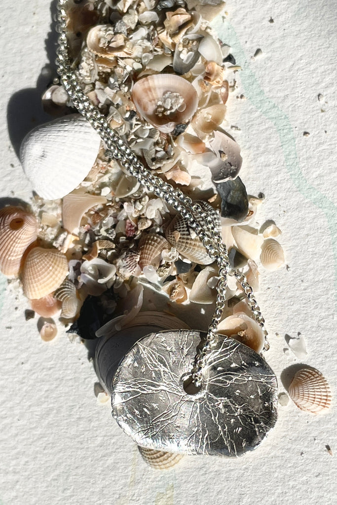 The centre piece is solid silver, it is designed to resemble bubbles and sea foam formed by the waves reaching the shore.