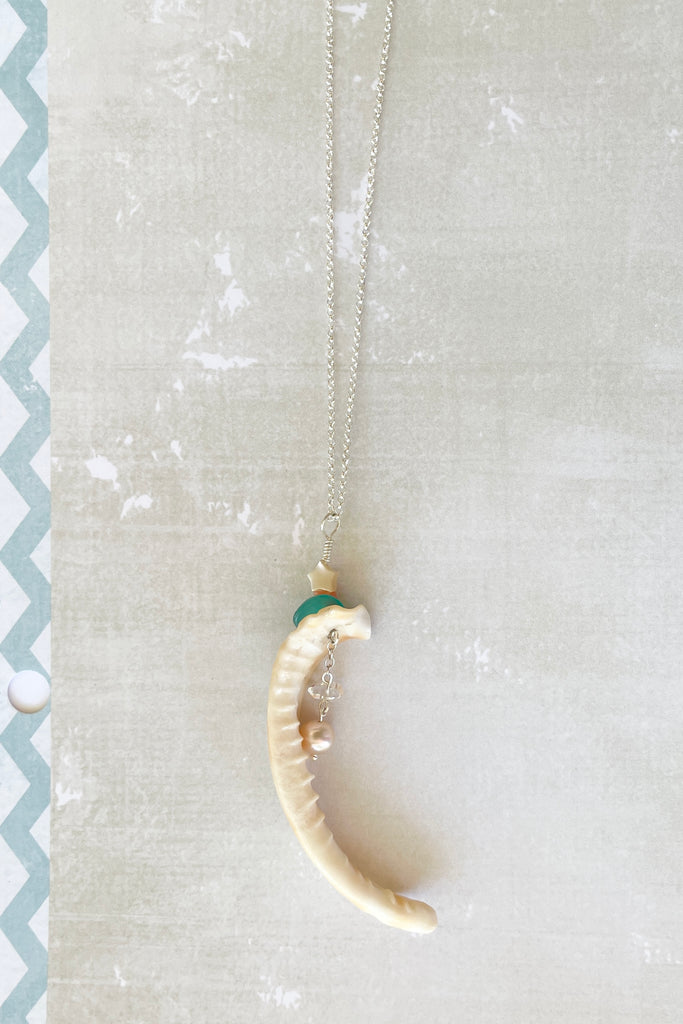 A beautiful cowrie shell lip as found on the beach, this has been turned into a pendant featuring a lustrous natural pearl, a Herkimer diamond an Amazonite bead and a mother of pearl star.