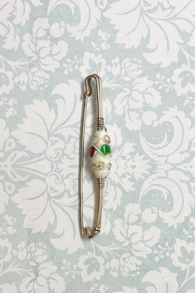An interesting vintage tie pin with gold wire work around a white lamp work bead. 