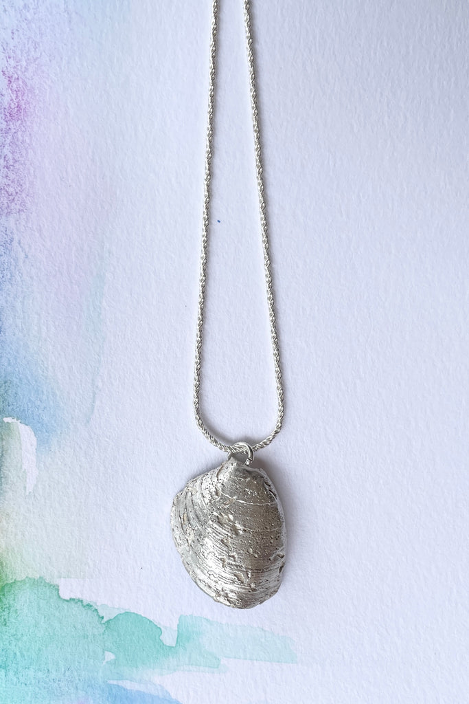  The centre piece is silver, it is cast from a little shell picked up on the Noosa beach. This pendant  is so quiet and it has a secret, the underside is enameled in deep sea blue, with a scattering of sand and rocks around the edge
