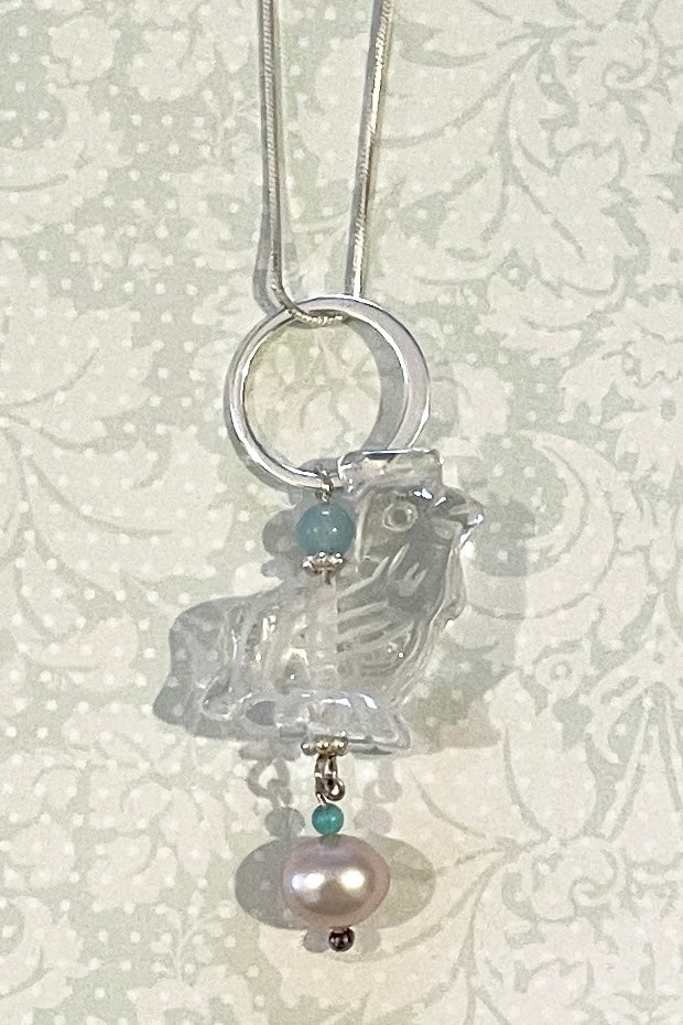 A little hand carved rock crystal rooster on a silver chain. With Amazonite and turquoise beads, a lovely pink pearl hangs at the base, this makes pendant perfection. 