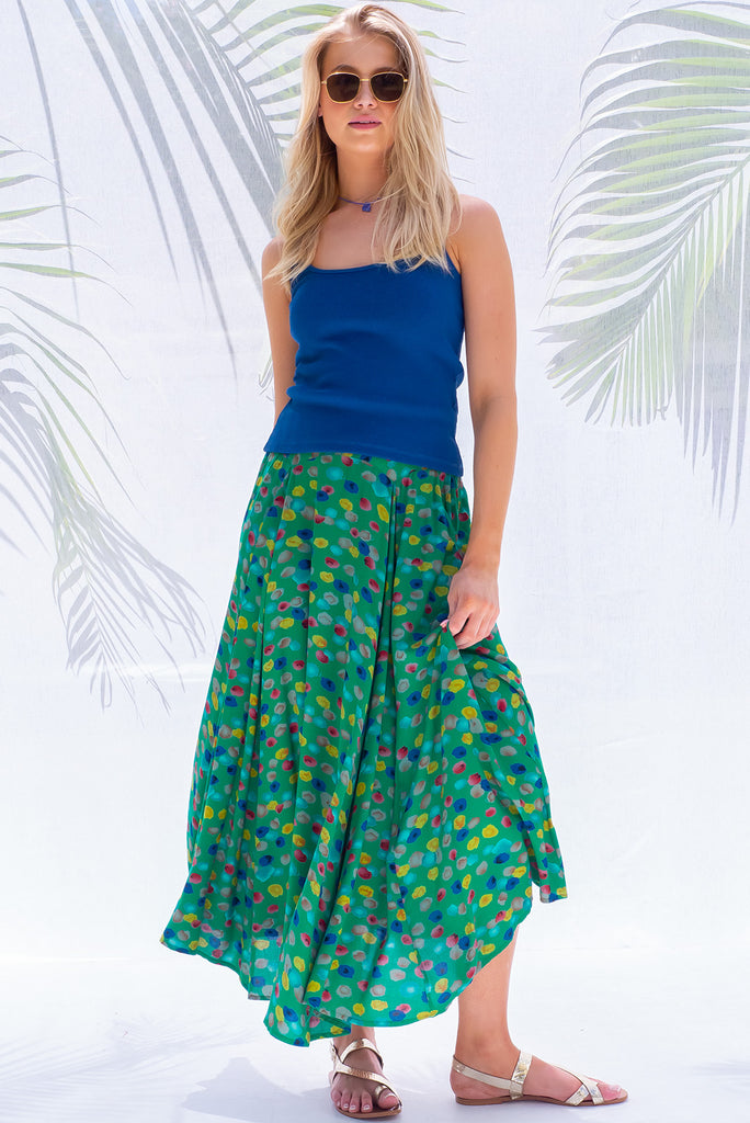 The Atlantis Jade Green Maxi Skirt is a gorgeous skirt with a jade green base and multicoloured spot print. The skirt features a double v-shaped waist yoke, inset panels on the front from the yoke down, very full skirt, elasticated back of waist and side pockets. This is a slip on design with a shapely hemline and slightly longer front due to the inset panels. Made from 100% Viscose.