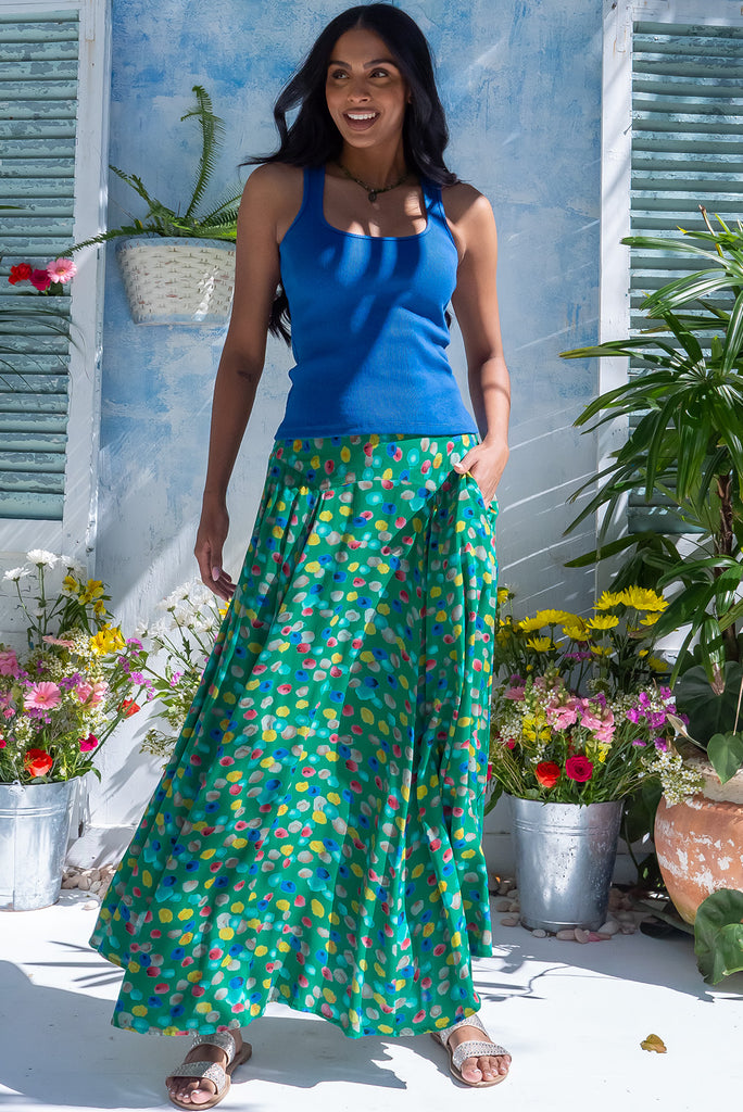 The Atlantis Jade Green Maxi Skirt is a gorgeous skirt with a jade green base and multicoloured spot print. The skirt features a double v-shaped waist yoke, inset panels on the front from the yoke down, very full skirt, elasticated back of waist and side pockets. This is a slip on design with a shapely hemline and slightly longer front due to the inset panels. Made from 100% Viscose.