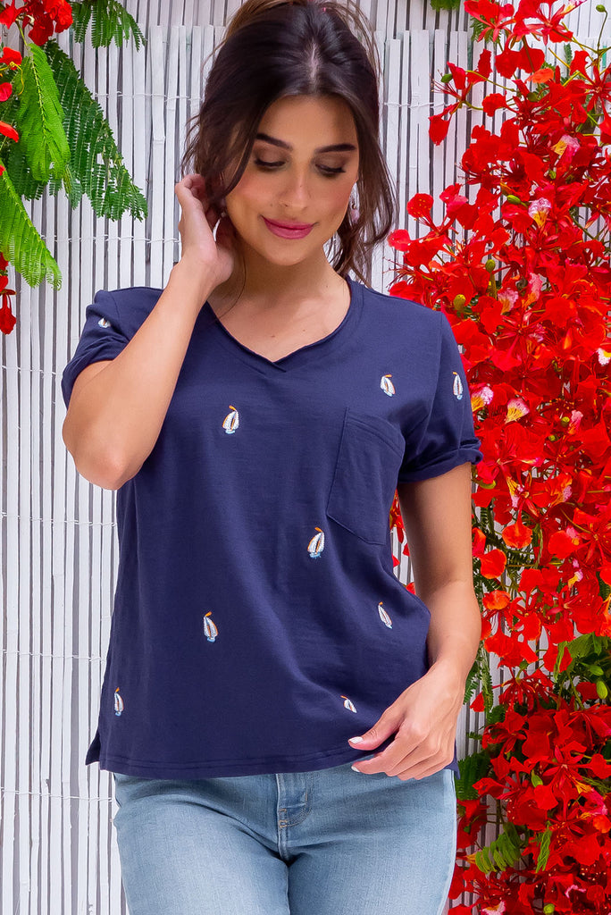 The Aurora T-Shirt Navy Yacht is a navy, relaxed fit, t-shirt with embroidered yachts all over. The shirt features a raw edged v-neck, front breast pocket, side spilt and rolled sleeve. Made from Knit 100% cotton.