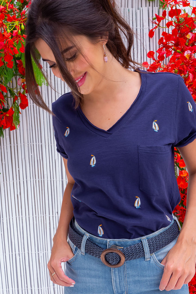 The Aurora T-Shirt Navy Yacht is a navy, relaxed fit, t-shirt with embroidered yachts all over. The shirt features a raw edged v-neck, front breast pocket, side spilt and rolled sleeve. Made from Knit 100% cotton.