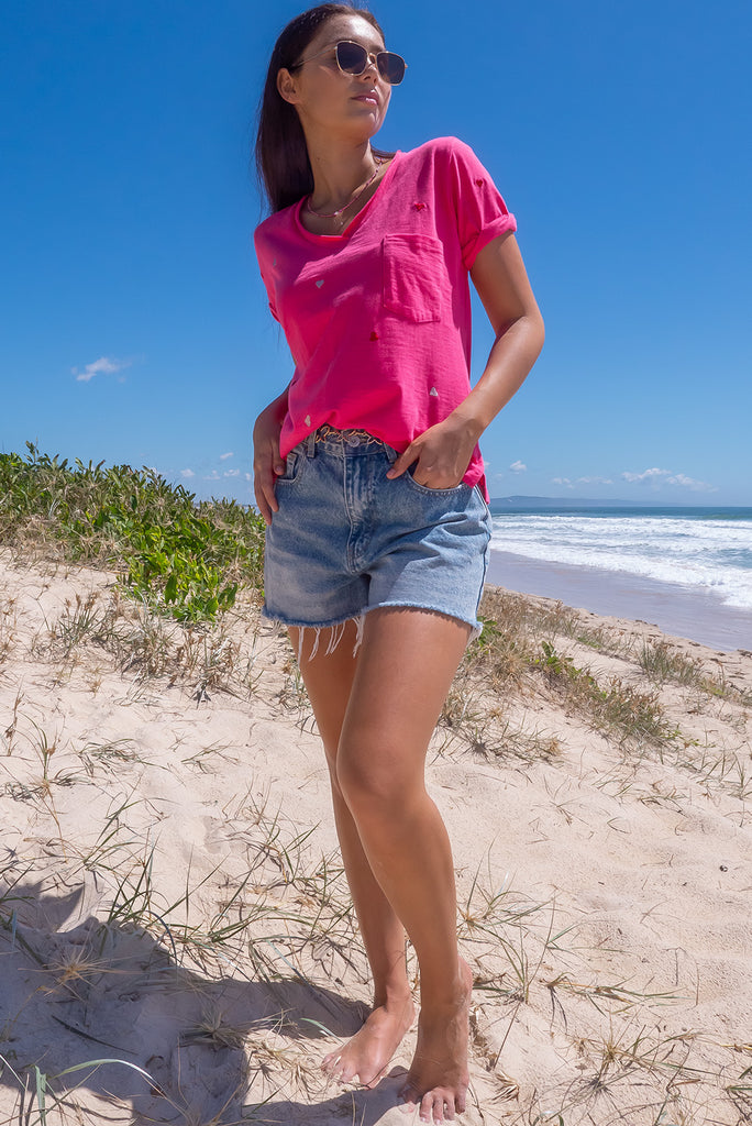 The Aurora T-Shirt Love Heart Red is a hot pink, relaxed fit, t-shirt with embroidered red and white hearts all over. The shirt features a raw edged v-neck, front breast pocket, side spilt and rolled sleeve. Made from Knit 95% cotton / 5% spandex.