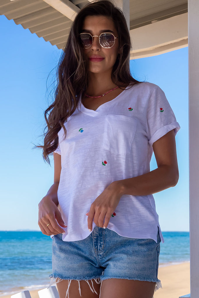 A simple and sweet flower print embroidered on a crisp, white cotton base makes the new Aurora T White Light a fresh alternative to the classic white tee. Knit 95% cotton/ 5% spandex, Lightweight, V-neck, Pocket on bust, Short cuff sleeves, Loose fit.