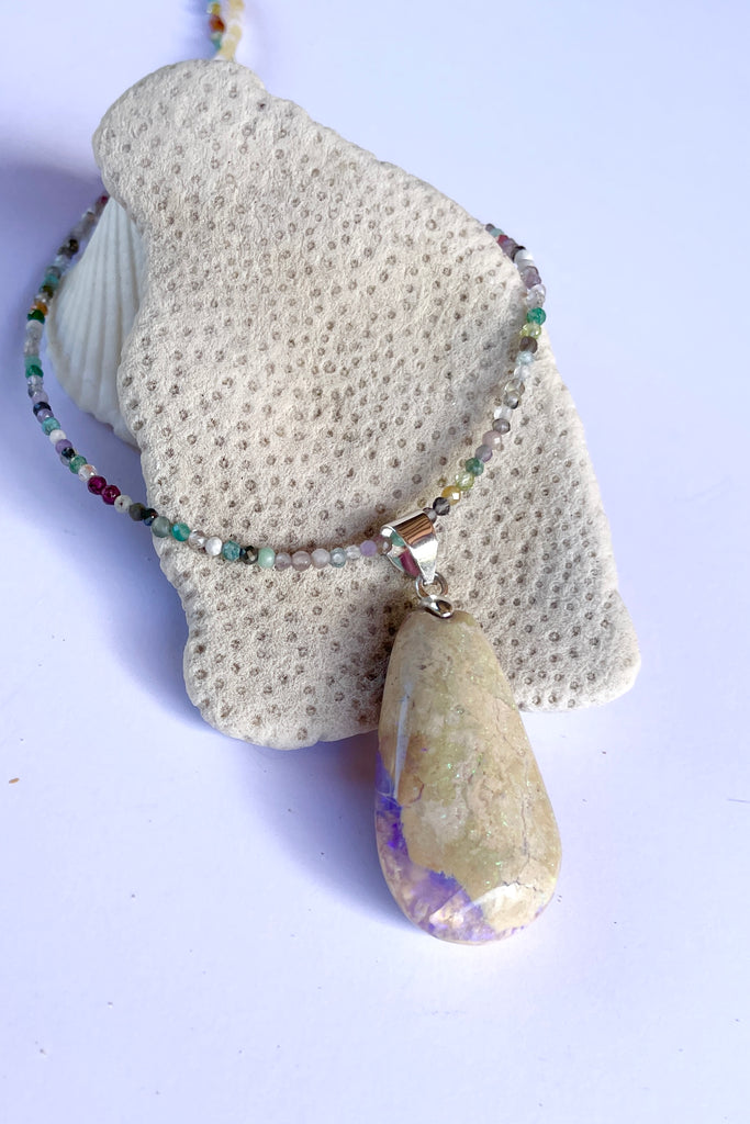 This opal is a one off piece, a hand cut and shaped light matrix opal, there is a lovely pale mauve crystal cave on one side, the top surface shows a mysterious bright green sparkle under sunlight.