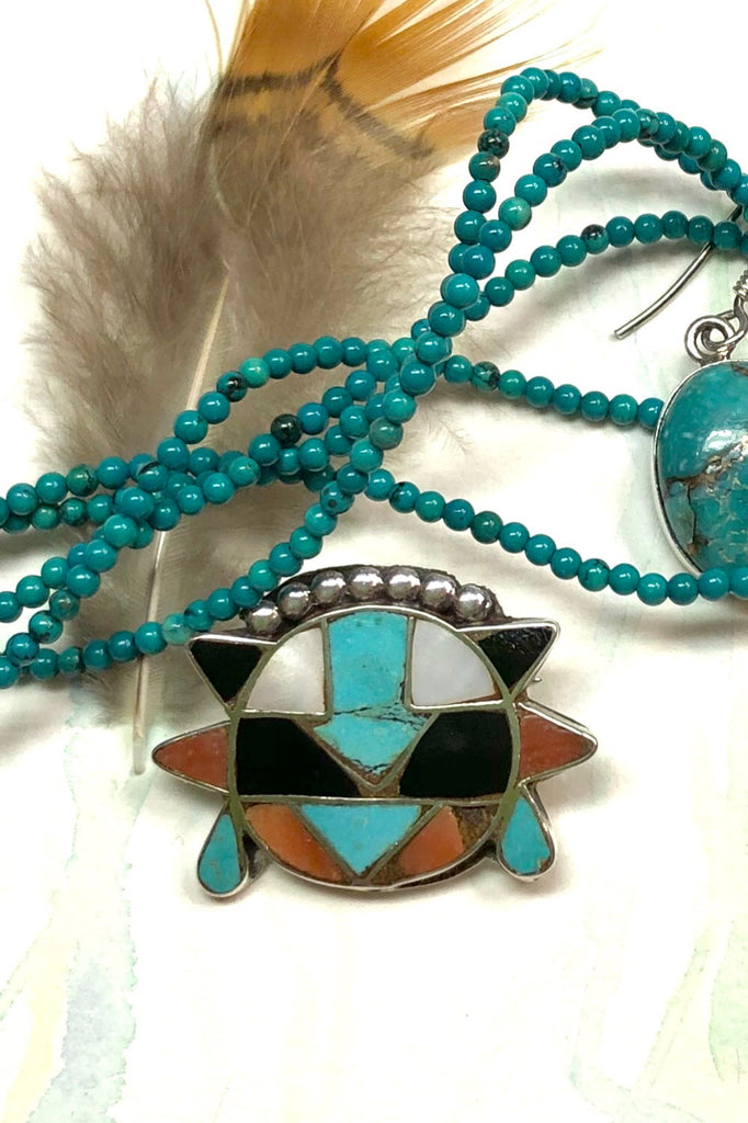 Echo Brooch Zuni Silver and Turquoise Inlay is a mysterious design brooch featuring turquoise stone, Coral and Shell.