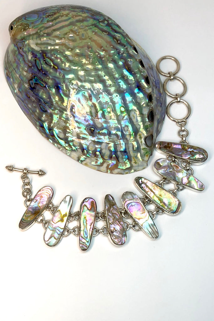 The Echo Bracelet Paua Sea has each link cut to enhance the gorgeous colours and  each shape individually set and rim set into 925 silver.  
