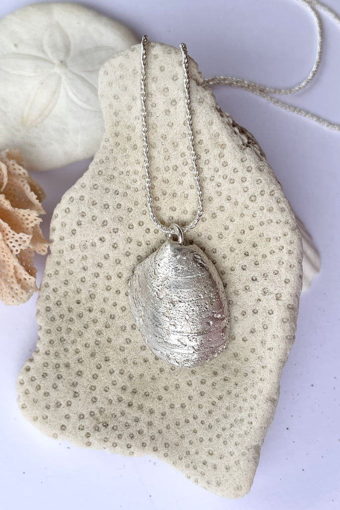  The centre piece is silver, it is cast from a little shell picked up on the Noosa beach. This pendant  is so quiet and it has a secret, the underside is enameled in deep sea blue, with a scattering of sand and rocks around the edge