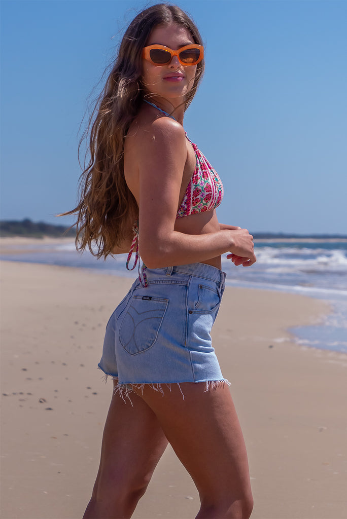 The Bikini Top Pink Stripe is a 100% woven rayon triangle cut bikini with a pink, green and white bohemian stripe design. The bikini top features an adjustable tie neck and back.