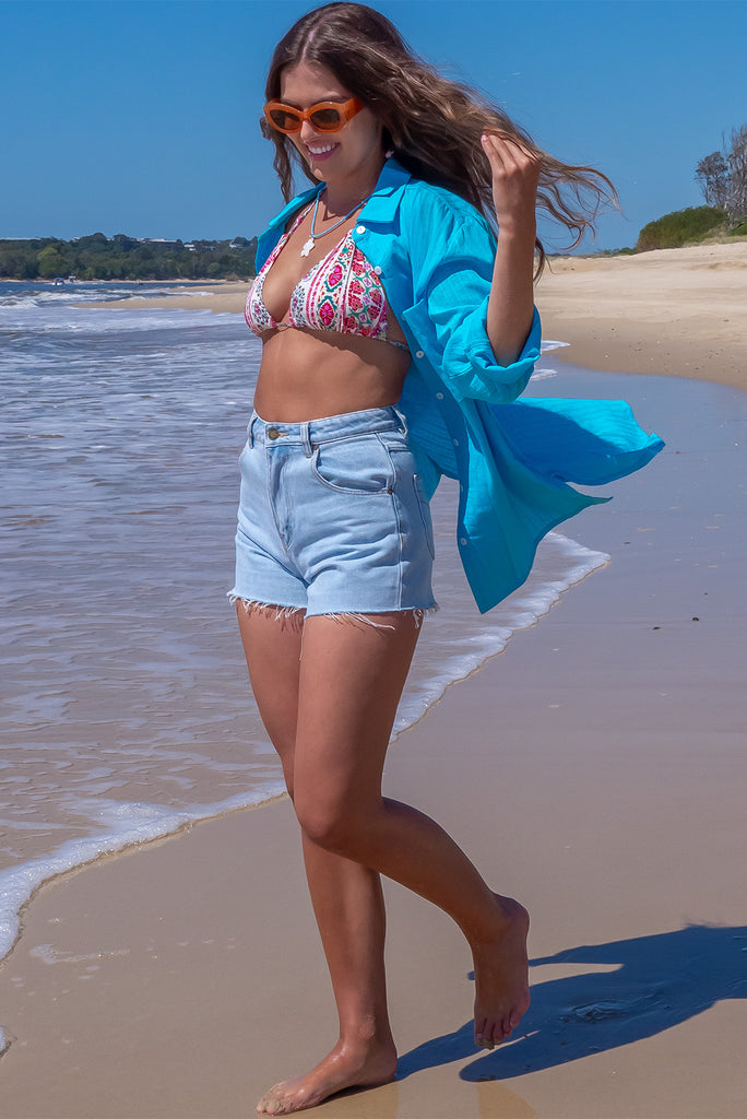 The Bikini Top Pink Stripe is a 100% woven rayon triangle cut bikini with a pink, green and white bohemian stripe design. The bikini top features an adjustable tie neck and back.