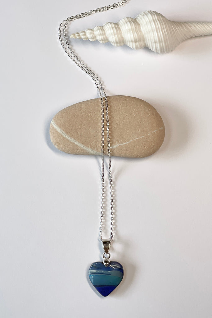 A blue boulder opal pendant There are lovely dark blue and teal blue stripes across the piece they are so well defined as to appear painted by nature.