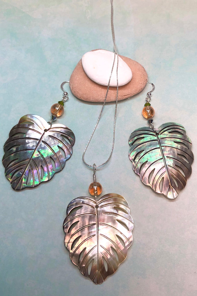 The gorgeous leaf pendant in gold and silvery bronze Mother of Pearl has been hand cut and polished. At the top there is an iridescent crystal bead.
