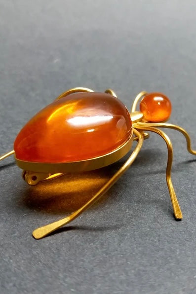 Features the form of a six legged bug with the head and body set with cabochons of natural Baltic honey amber. Marked on underside. A super quirky insect brooch