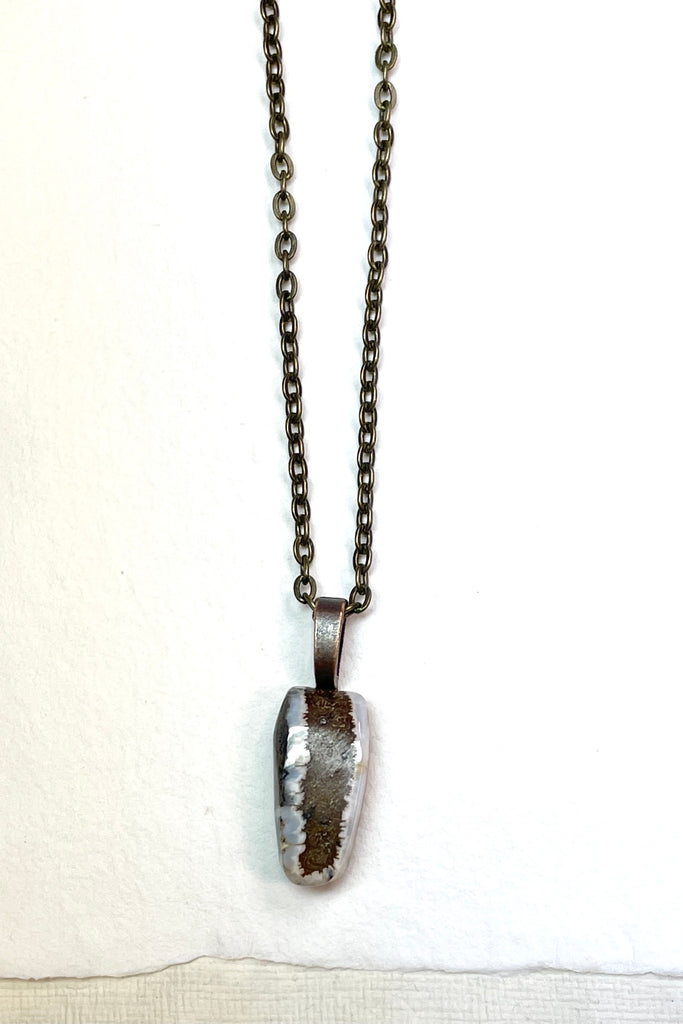  The pendant has a band of rock running down the centre and the edges have a crystalline opal edge.