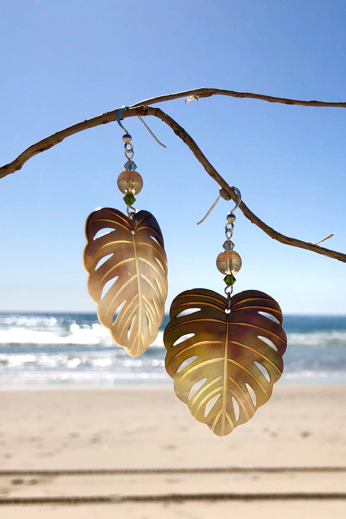 The gorgeous leaf in gold and silvery bronze Mother of Pearl has been hand cut and polished. At the top there is an iridescent crystal bead and a swarovski crystal bead. These earrings are made exclusively for Mombasa Rose