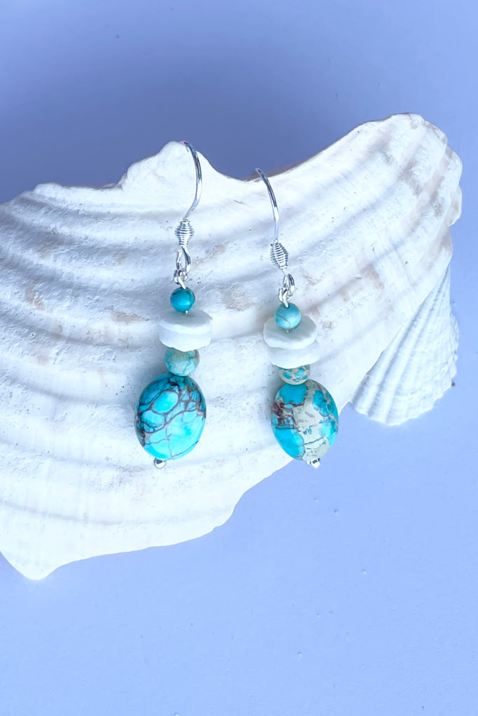 Tiny and pretty these earrings have a little turquoise howlite bead and hand cut shell beads.