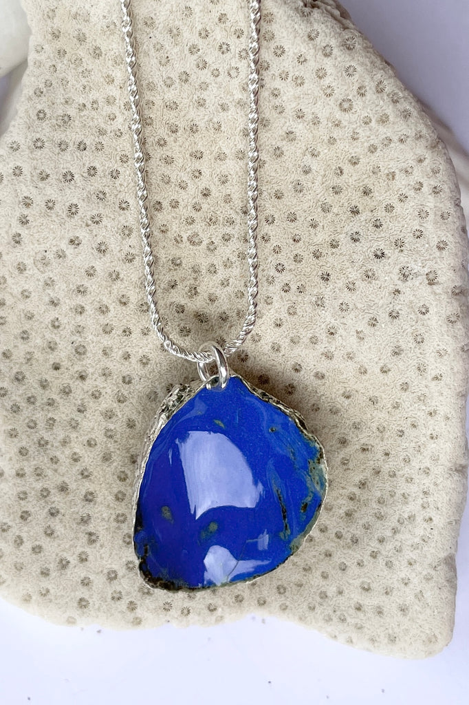  The centre piece is silver, it is cast from a little shell picked up on the Noosa beach. This pendant  is so quiet and it has a secret, the underside is enameled in deep sea blue, with a scattering of sand and rocks around the edge