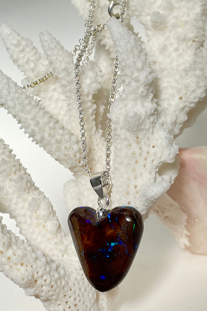 This intriguing and unique piece of opal was cut and polished into the heart shape for Mombasa Rose in Noosa, Queensland. The flashes of turquoise and teal go across and deep into the stone, giving it a flashing twinkling look. 