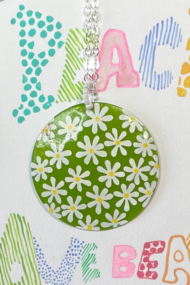 sweetheart daisy necklace is a Capiz shell circle hand painted with 60's style daisies